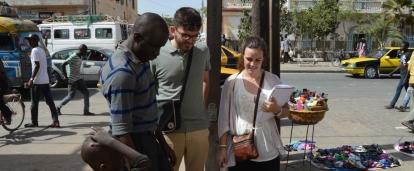 Projects Abroad interns speak to a local street vendor during their Human Rights work experience in Senegal. Students talk to a local street vendor during their Human Rights internship in Senegal.